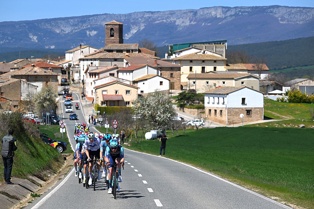 The peloton rode the two-lane road leading out of town